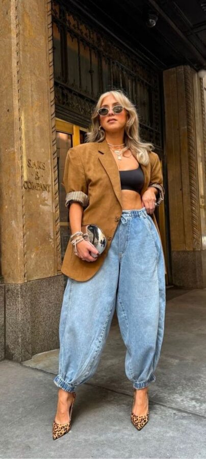 Woman wearing light-wash baggy jeans with a tan blazer and leopard heels