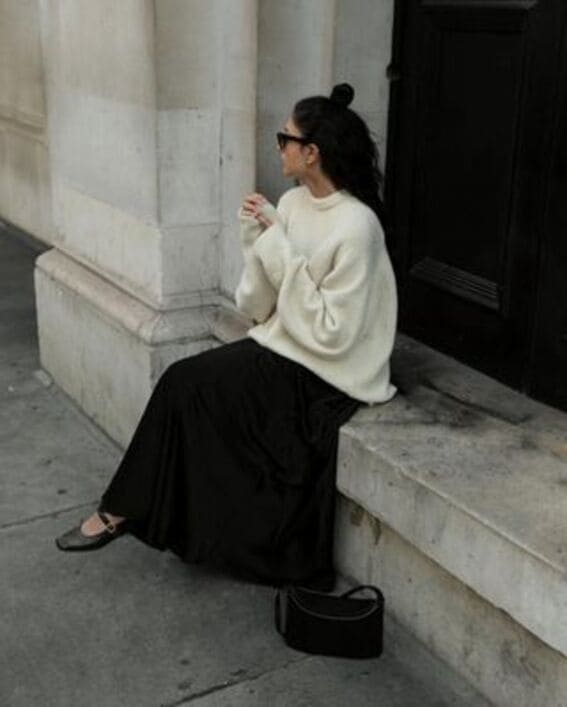 The floor-sweeping maxi skirt is styled casually with a fitted top and sneakers.