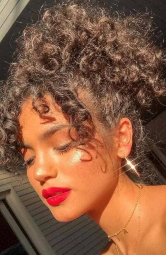 High ponytail featuring lush, voluminous curls.