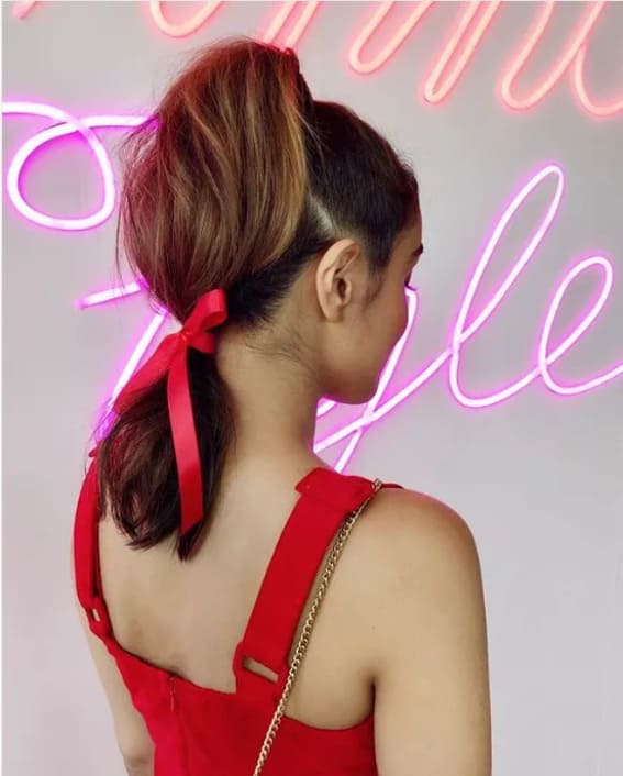 Elegant ponytail updo with ribbon for a sophisticated look.