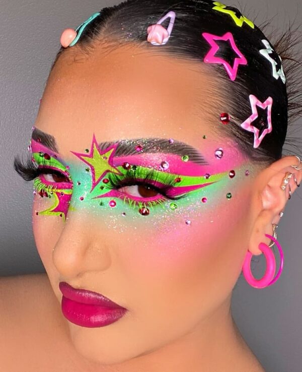 Vibrant neon and green galaxy-inspired eye makeup with star-shaped designs and pink accents.