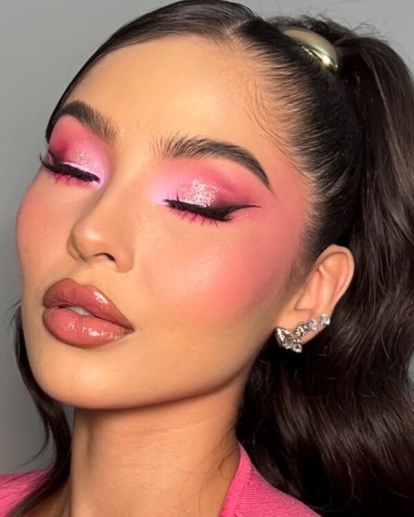 Close-up of soft pink eye makeup with glossy lips and radiant blush.