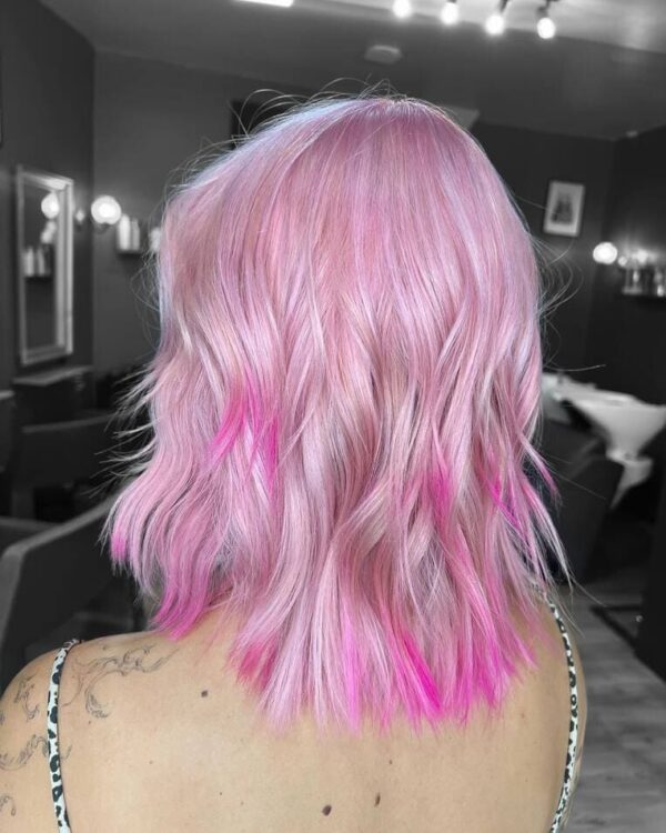 A back view of her wavy, pastel pink hair with Hot pink tips.