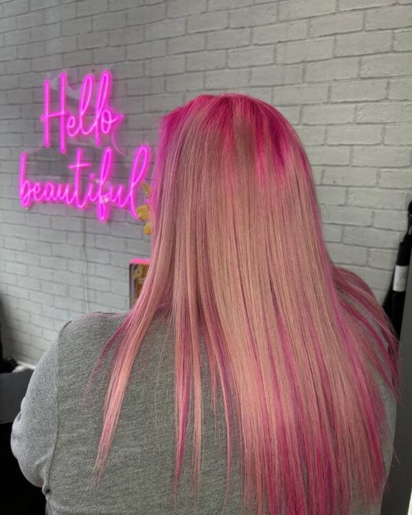 Back view of straight, blush pink hair, with neon pink on the crown.