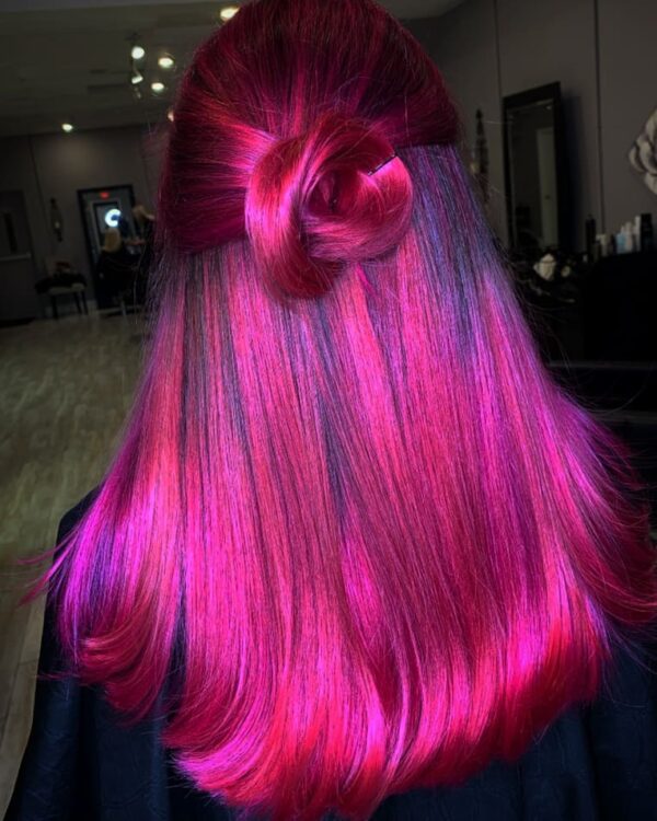 View back of bright pink hair with a clean, shiny style with an up-knot half-up.