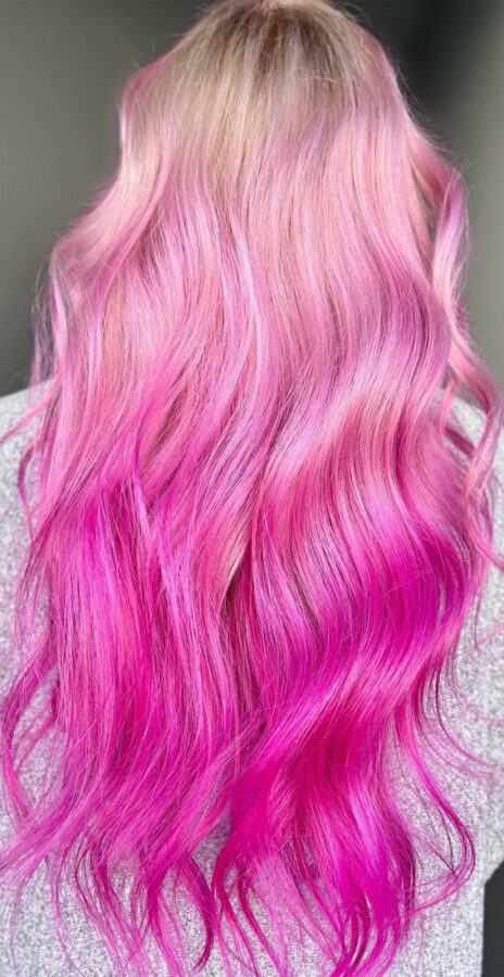 Long wavy hair with a pink ombre gradient from soft pastel to vibrant magenta