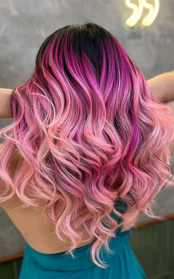 Long wavy hair with dark roots and pink ombre coloring