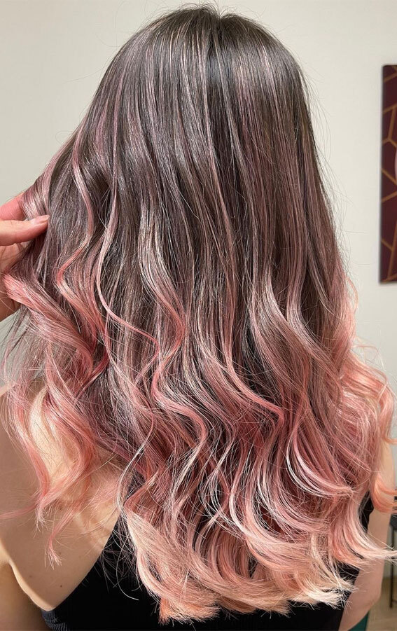 Medium-length wavy hair with soft pink balayage on a dark base