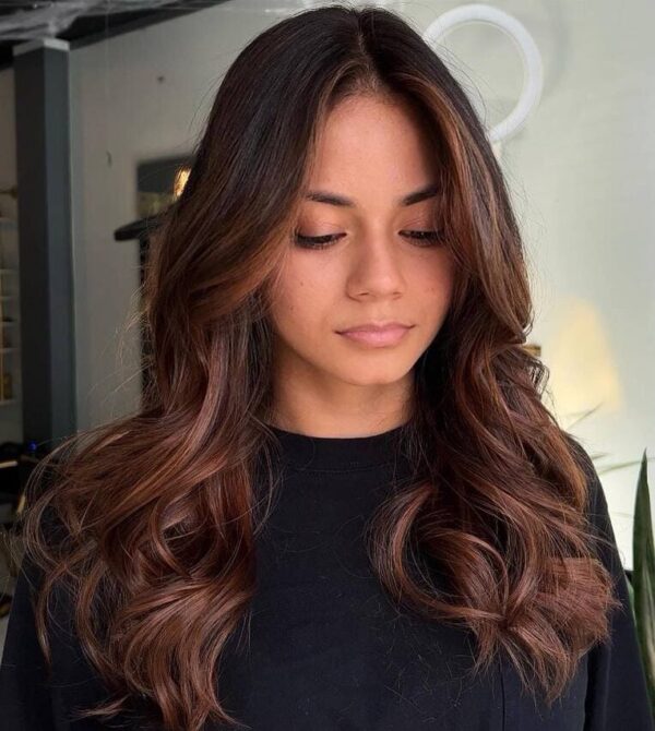 Bright copper balayage on shoulder-length hair with a shiny finish.