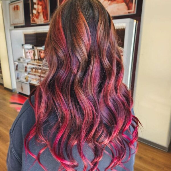 Fiery red and pink ombre hairstyle with natural waves.