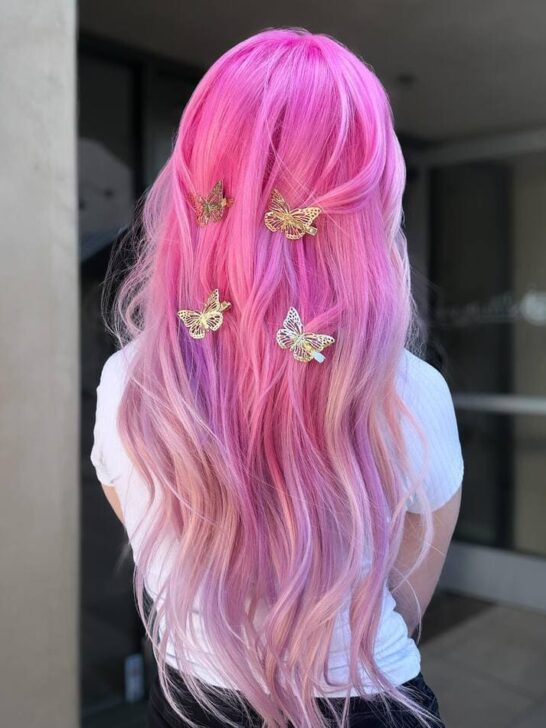 Pink ombre hair with butterfly hair clips, transitioning from bright pink to pastel purple.