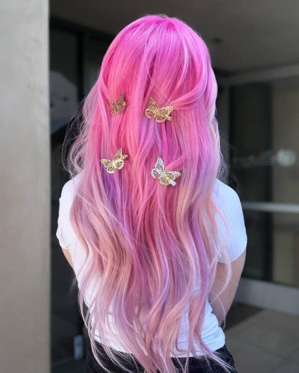 Pink ombre hair with butterfly hair clips, transitioning from bright pink to pastel purple.