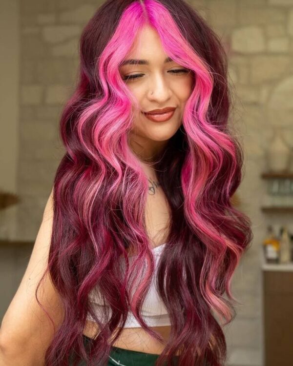 Long, wavy burgundy hair with neon pink highlights at the front.