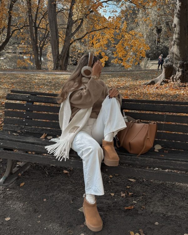 Cozy park bench outfit featuring white jeans, platform UGG boots, and earmuffs.