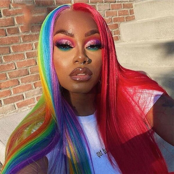 Front view of a vibrant rainbow wig with red, blue, green, and yellow sections flowing down in sleek, straight strands.