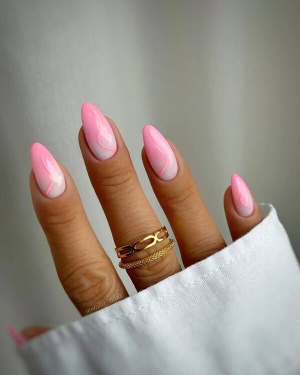 Almond-shaped nails with a soft gradient pink base and delicate pink swirl accents for a clean, dreamy finish.